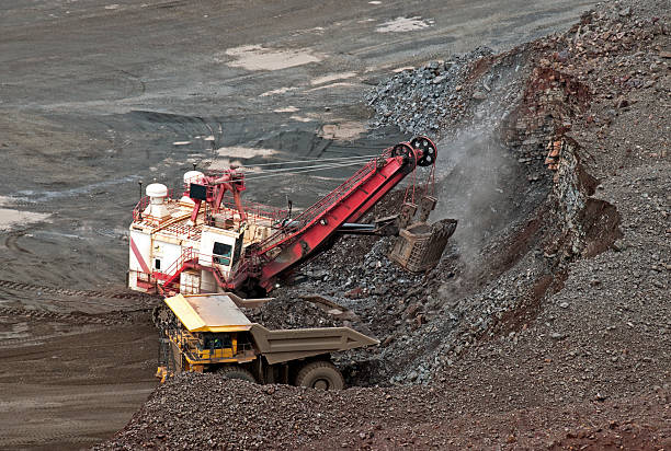 istock Crane bucket loading iron ore into truck at mine 175207442