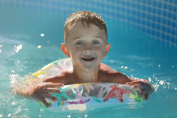 istock Portrait smiling boy in swimming pool, child with inflatable ring. Summer vacation or classes. Summertime and swimming activities for happy children on the pool 1752080064