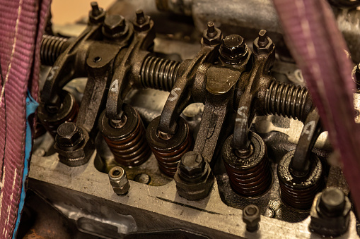 Close-up showcasing the intricate valves of a vintage engine undergoing meticulous restoration.