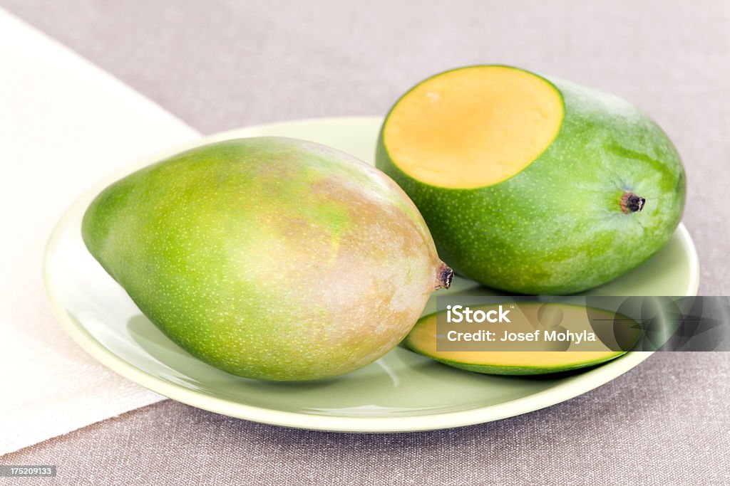 Mangoes on plate Two ripe mangoes on plate. Selective focus, shallow DOF. Cross Section Stock Photo
