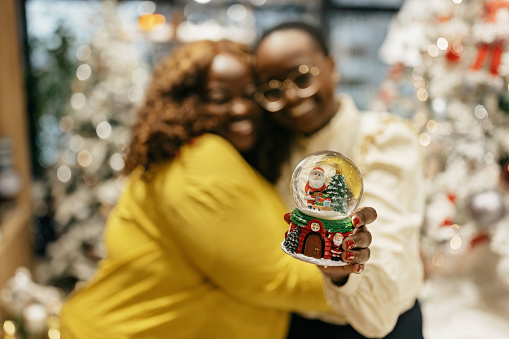 Two young african american woman holding snow globe