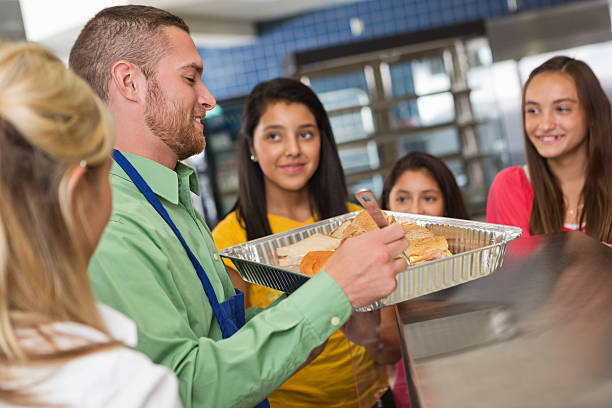 istock Cafeteria workers serving food to students in lunch line 175209662