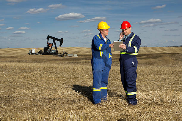 масло работники и техники - oil industry digital tablet manual worker mining стоковые фото и изображения