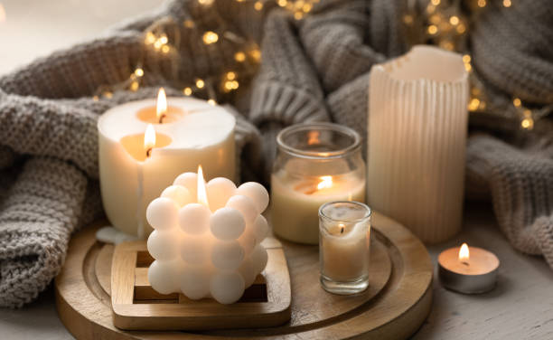 A cozy composition with candles, a knitted element and a garland.