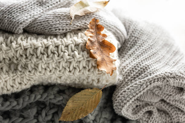 istock Close-up of a stack of knitted sweaters with autumn leaves. 1752105711