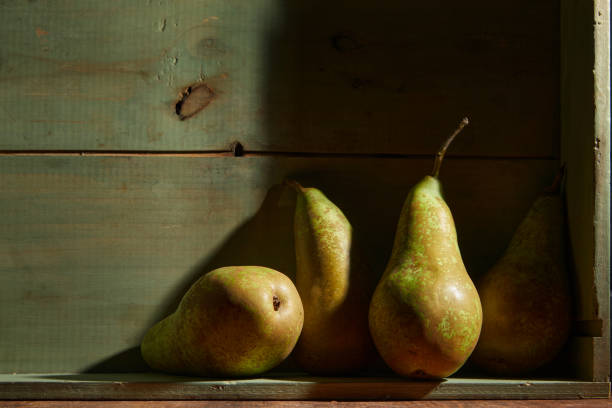 Image of Still Life with a stack of green Pears. Rustic wood background, antique wooden table stock photo