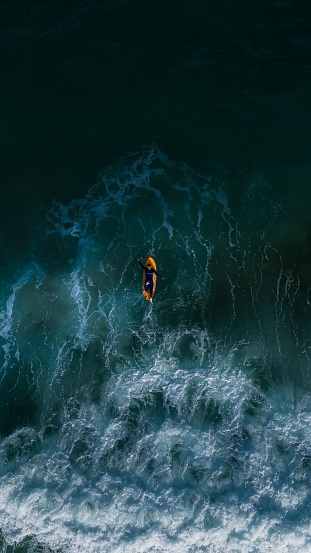 A surfer in a wet suit enjoying the thrill of surfing in the crystal blue waters of the ocean