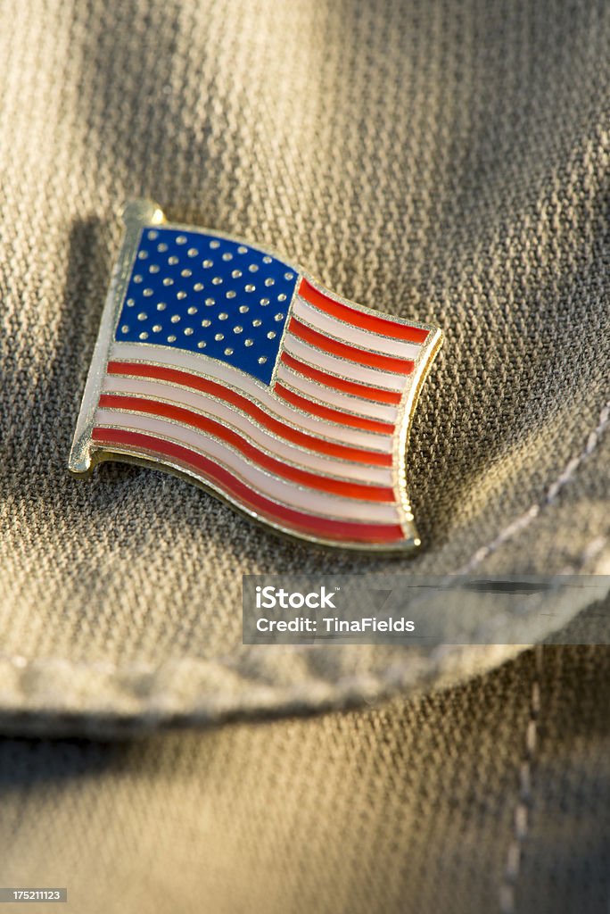 USA flag label pin. "United States of America flag lapel pin on a brown jeans shirt, selective focus on the red and white stripes." American Flag Stock Photo