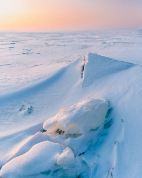 istock A frozen surface of ice with snow intersected by many cracks. 1752113639
