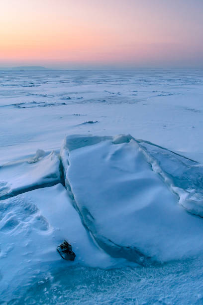 istock A frozen surface of ice with snow intersected by many cracks. 1752113641