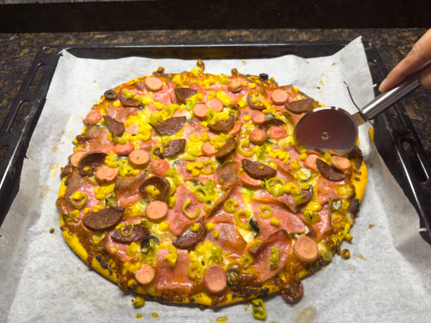 Cutting a freshly baked hommade pizza with a pizza cutter