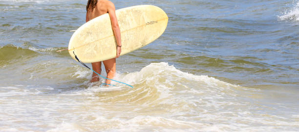 istock Surfer staniding on the waters edge ready to go into the ocean to surf 1752118029