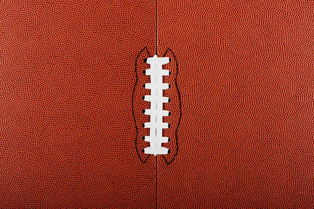 American Football Background. A flat football with seam and white laces for a background