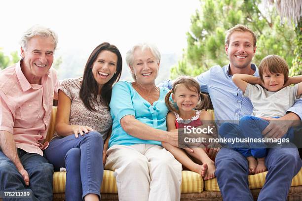 Multi Generazione Della Famiglia Seduto Sul Sedile Giardino - Fotografie stock e altre immagini di Famiglia multigenerazionale