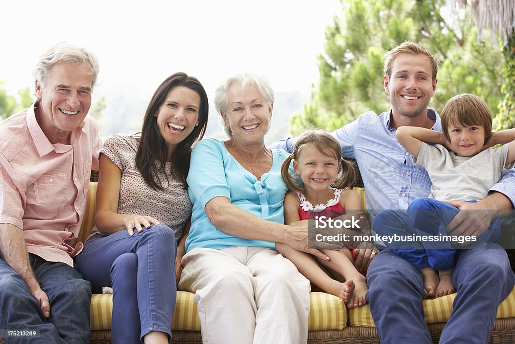 Várias gerações de família sentada no jardim - Foto de stock de Família de várias gerações royalty-free