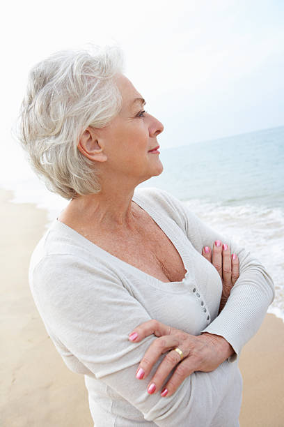 istock Thoughtful Senior Woman Standing On Beach 175213478