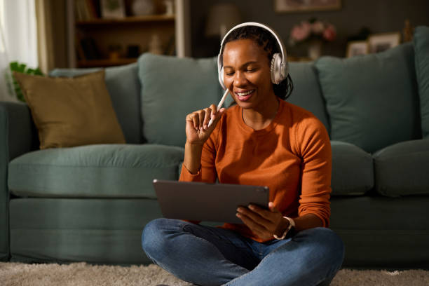 istock Woman with headphones using tablet and digitized pen at home 1752137481