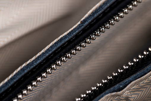 metal zipper on a black leather product, zipper on a black women's handbag close-up