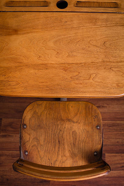 Vintage School Desk Sitting On Hardwood Floor, Overview "Close up, color image of the view looking down on a vintage school desk sitting on a hardwood floor." classroom empty education desk stock pictures, royalty-free photos & images