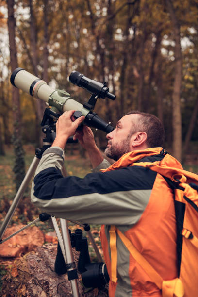 istock Man using telescope for bird and animal watching in nature. 1752172050