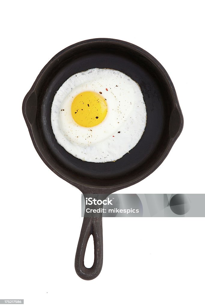 Cast iron skillet with fried egg isolated on white. Looking directly down on a fried egg in a cast iron frying pan. Egg - Food Stock Photo