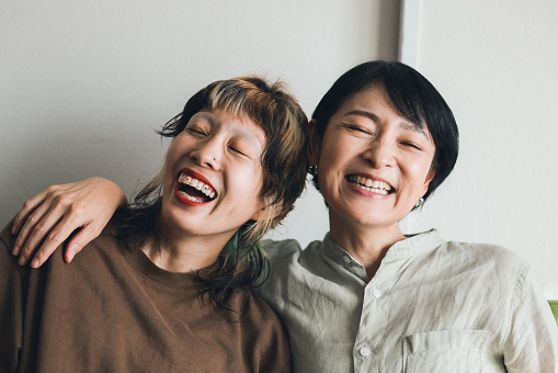 An asian mum with cancer and her adult daughter spend time laughing and bonding together as she goes through cancer treatment.