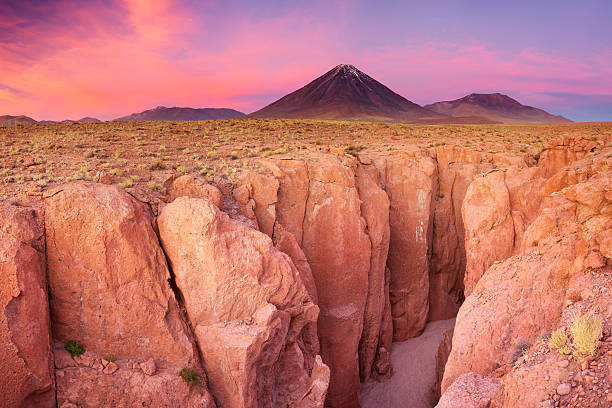 Narrow canyon and Volcan Licancabur, Atacama Desert, Chile at sunset "A narrow canyon with a volcano in the distance. Photographed at the foot of Volcan Licancabur in the Atacama Desert, northern Chile, at sunset. A seamlessly stitched panoramic image." atacama desert photos stock pictures, royalty-free photos & images