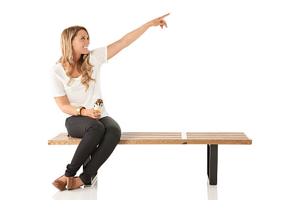 istock Woman sitting on a bench with ice cream and pointing 175218811