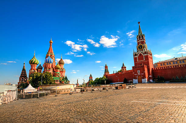 Red Square with Kremlin and St Basil's Cathedral in sun Beautiful view of empty Red Square with St Basils Cathedral and Moscow Kremlin. Beautiful blue sky with cumulus clouds on such a sunny day in Moscow. Copy Space for your text. red square stock pictures, royalty-free photos & images