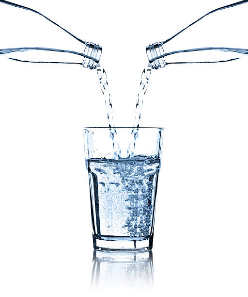 istock Pouring water from two bottles into glass, studio shot, isolated 175218856