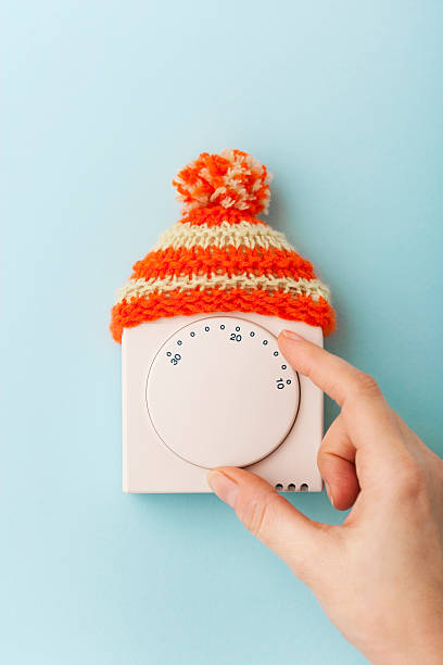 House thermostat with wooly hat stock photo