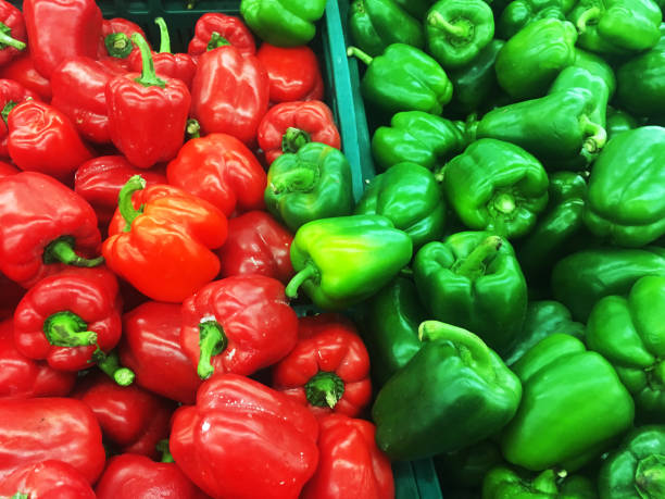 赤と緑のピーマンのトウガラシは、生鮮市場で販売のために表示されています - pepper bell pepper market spice ストックフォトと画像