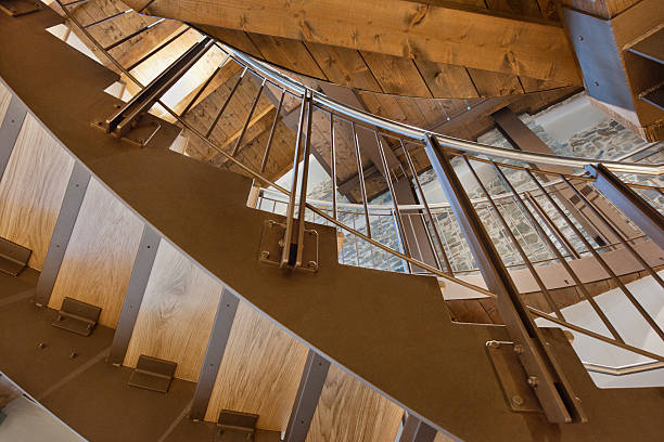 istock Modern steel wooden curved staircase, railing and structure, from below 175220278