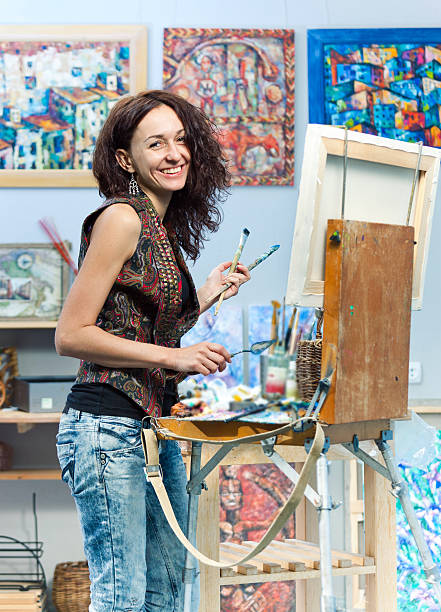 istock Smiling artist painting in her studio 175221645