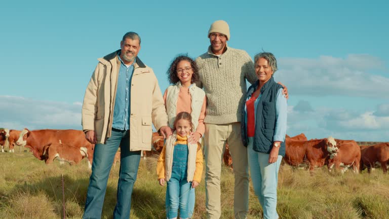 Nature, smile and portrait of family on a farm with herd of cows for livestock business in a field. Happy, love and girl child standing with grandparents and parents by group of cattle in countryside