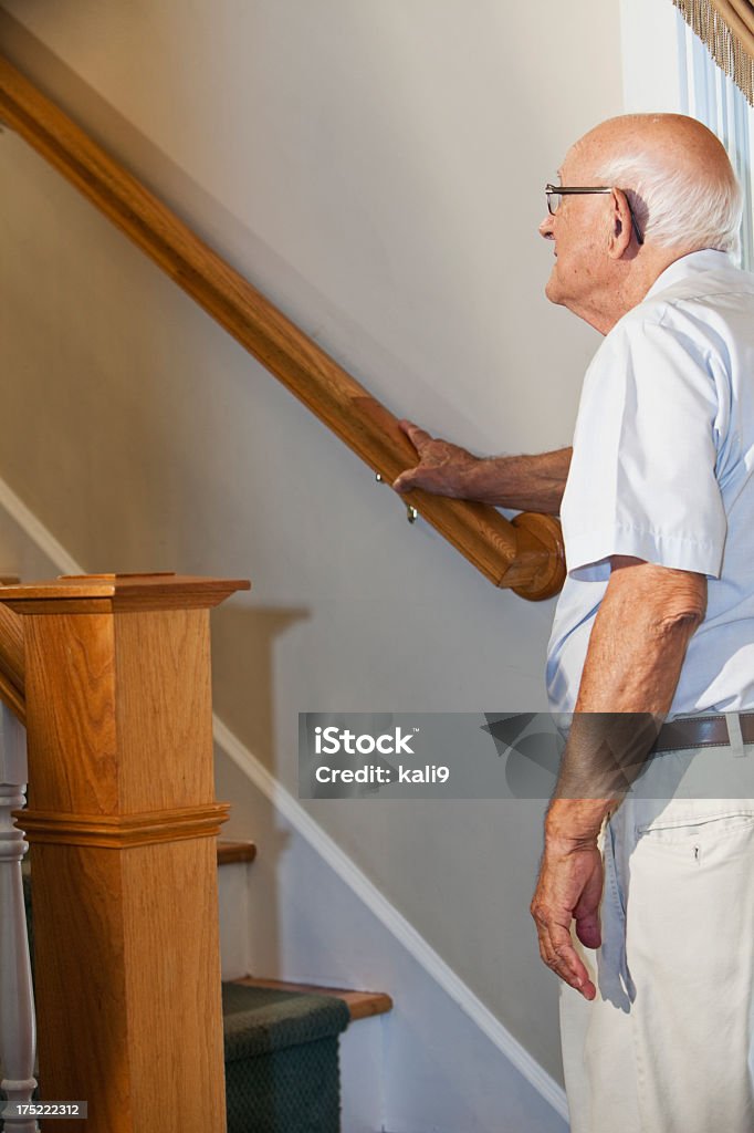 Uomo anziano in fondo alla scalinata ricerca - Foto stock royalty-free di Scalinata