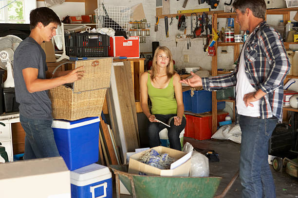 Father Organising Teenagers Clearing Garage Father Organising Two Teenagers Clearing Garage For Yard Sale cluttered photos stock pictures, royalty-free photos & images