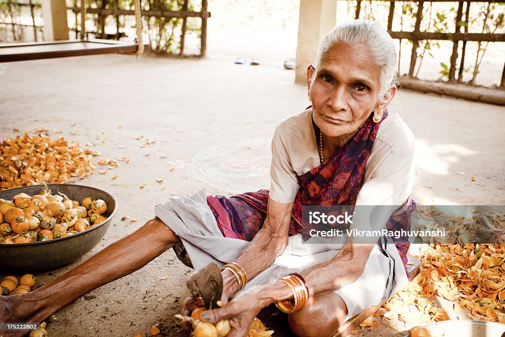 Senior mujer India asiática en campo descamación Betel tuerca - Foto de stock de 70-79 años libre de derechos