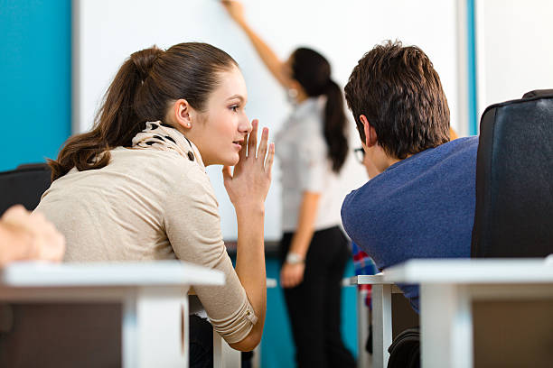 adolescente estudiantes hablando durante la clase - whispering couple discussion smiling fotografías e imágenes de stock