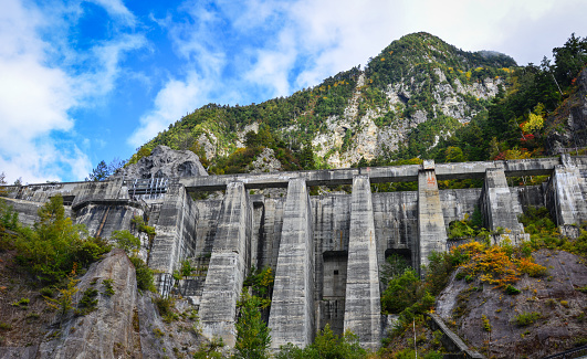 Kurobe Dam at autumn in Toyama, Japan. The Kurobe Dam is a 492 m long and 186 m high, with variable-radius (dome) arch dam.