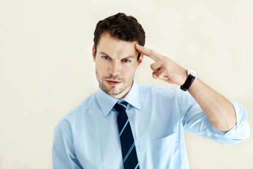 Portrait of a businessman wearing a tie pointing his finger to his head