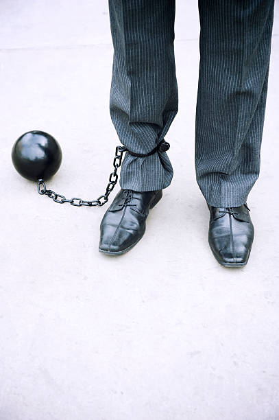 istock Businessman Stands with Ball and Chain on Stark Background 175224432