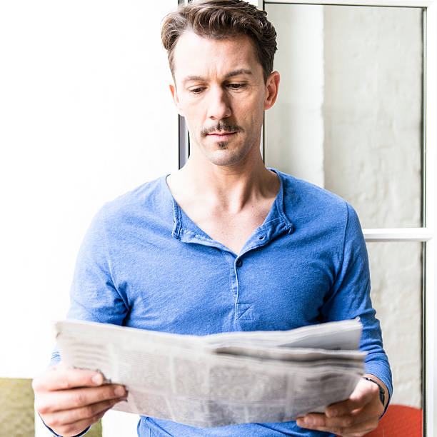 istock man reading a newspaper on the window 175224672