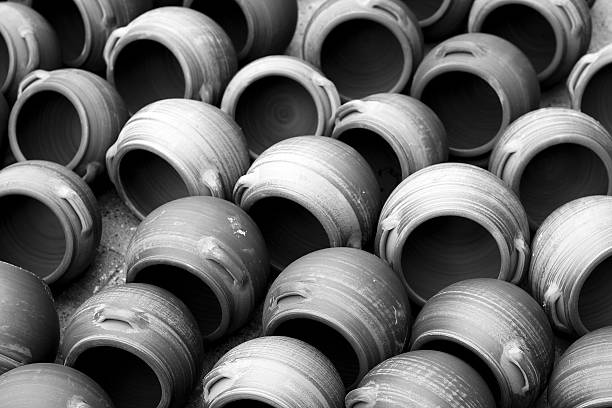 traditional clay pots stacked for sale in the market, black and white.