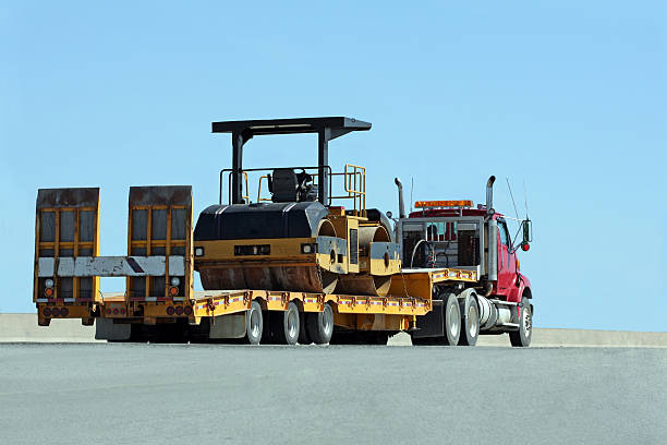 a wide construction machine on a trailer