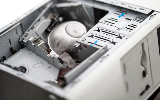 disassembled completely damaged computer with aluminium bowl inside, studio closeup