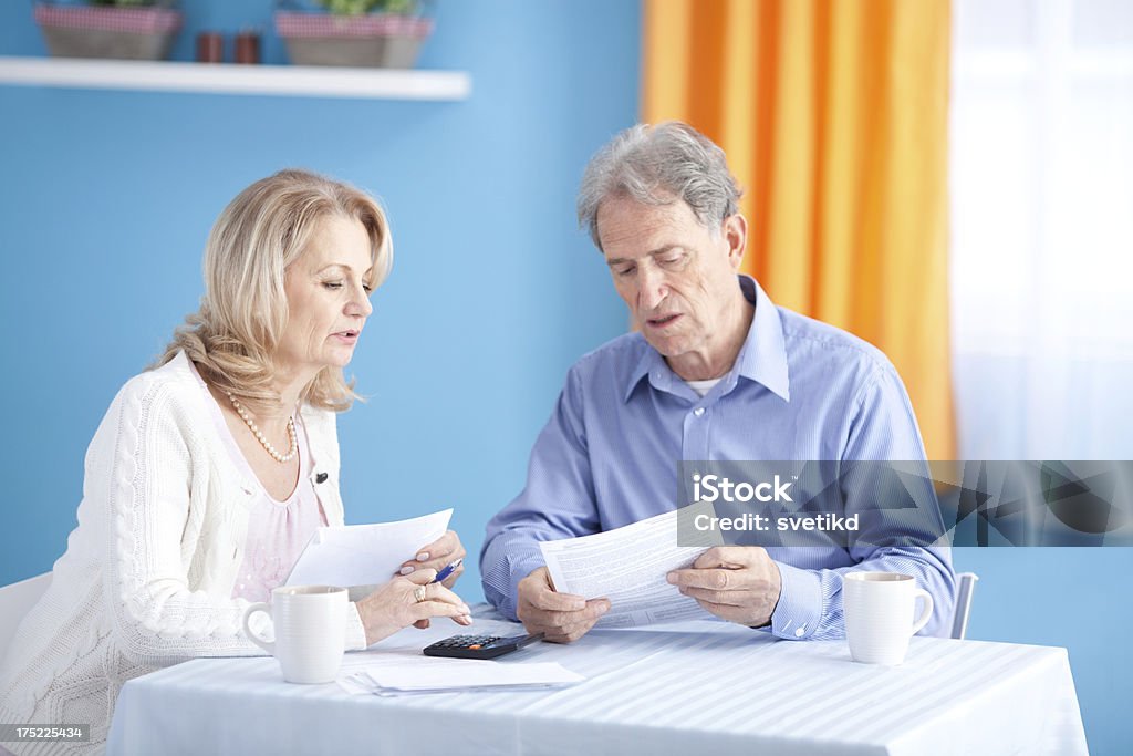 Senior couple with bills. Serious senior couple with bills.See more KITCHEN and LIFESTYLE images with this SENIOR CUOPLE. For lightbox click any image below. 60-64 Years Stock Photo