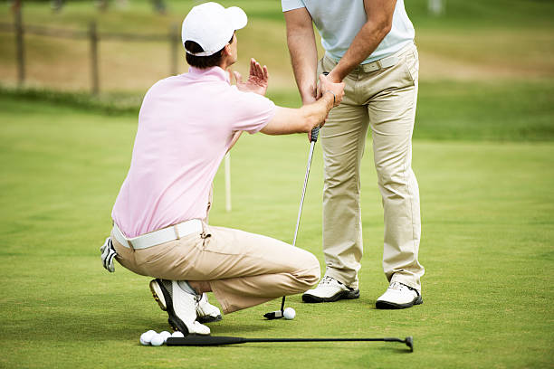 Golf Pro Teaching Male Golfer Golf pro teaching male golfer on putting green. golf concentration stock pictures, royalty-free photos & images