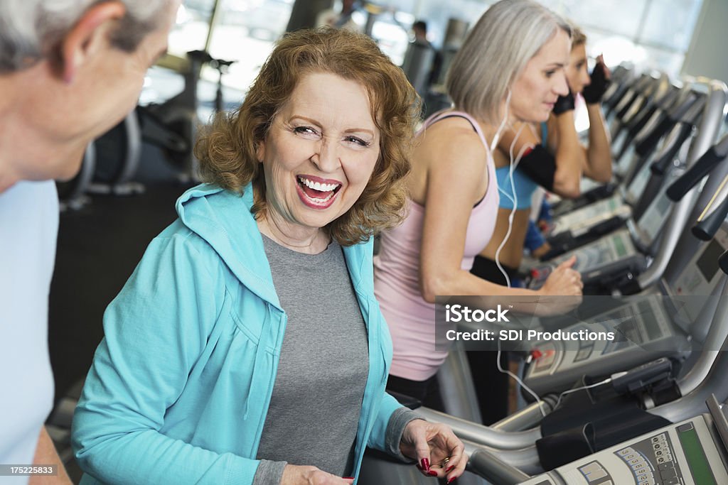 Deux Senior dynamique en faisant de l'exercice sur tapis de course dans la salle de sport. - Photo de Activité libre de droits