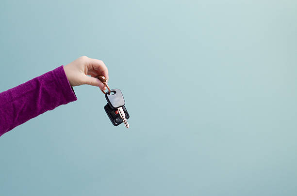 petite main possède un jeu de clés de voiture - human hand key giving carrying photos et images de collection